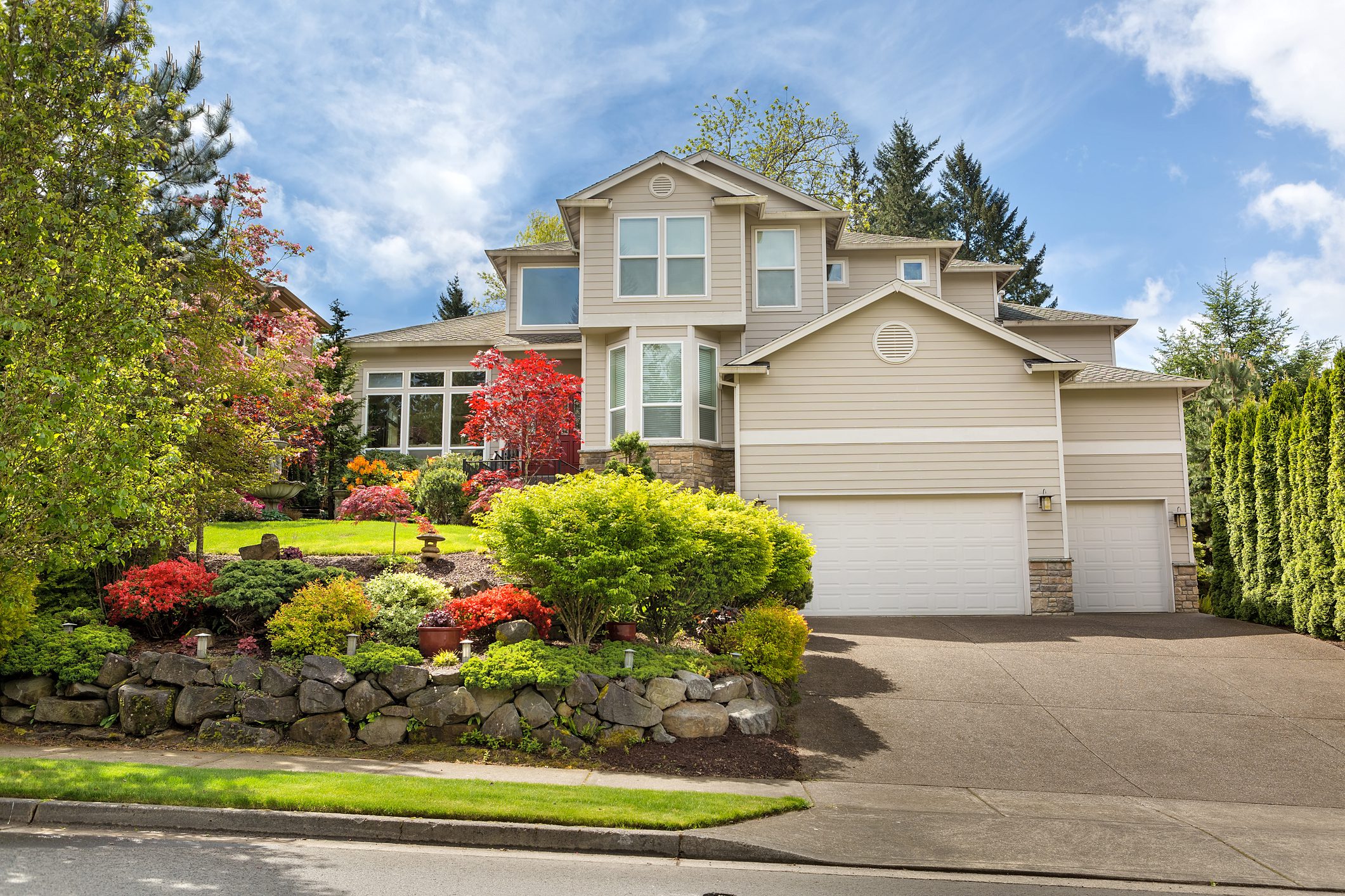 Two-story home with vibrant plants